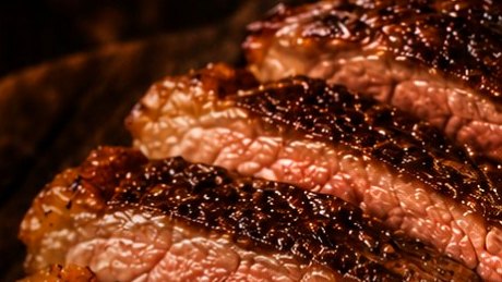Cortes de picanha fatiados sobre a brasa
